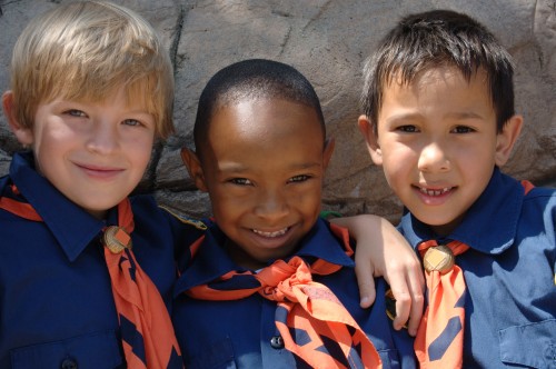 Three boys of diverse ethnic background in cub scout uniforms