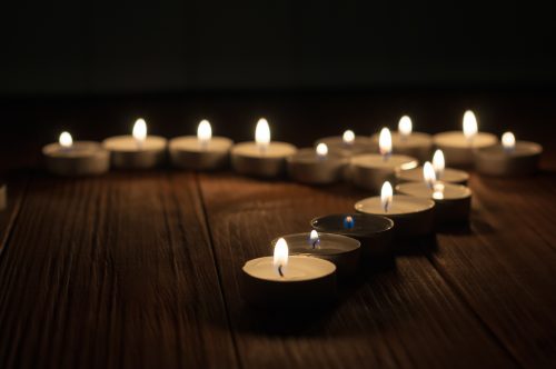 One candle and Candles on old wooden background